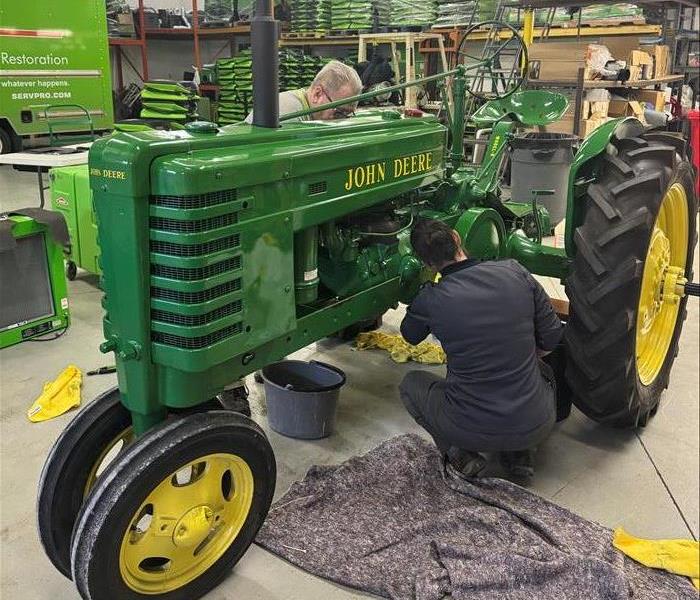 tractor being cleaned by employees