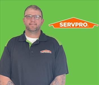 a man in front of a SERVPRO background