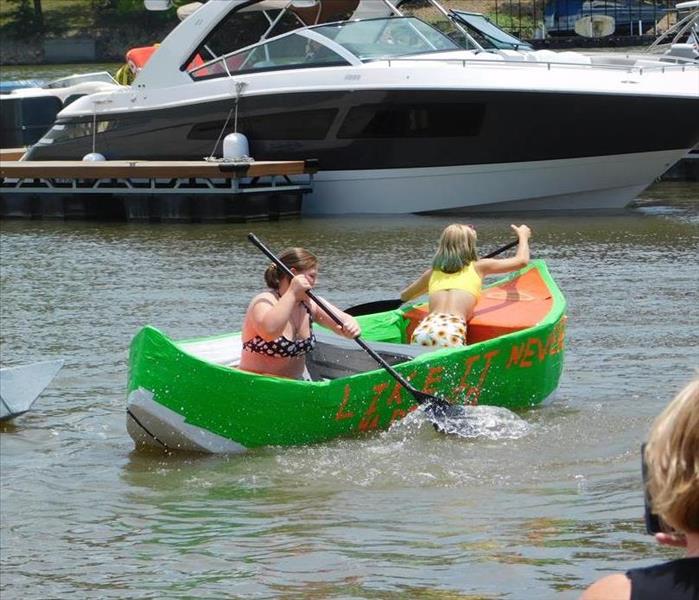 people paddling a green boat
